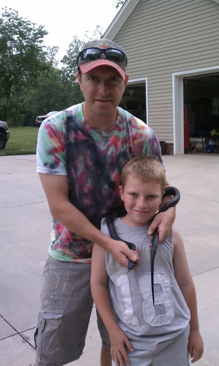 Bryson as a kid with a black rat snake draped over his shoulders